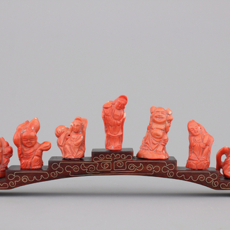 A set of 7 Chinese red coral figures of immortals on stand, 19/20th C.