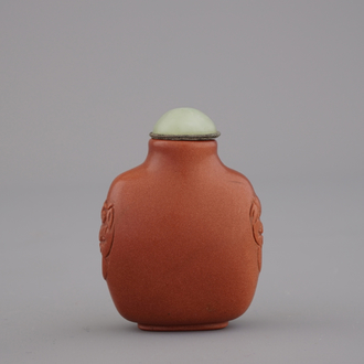 A Chinese polished gold stone snuff bottle with celadon jade lid