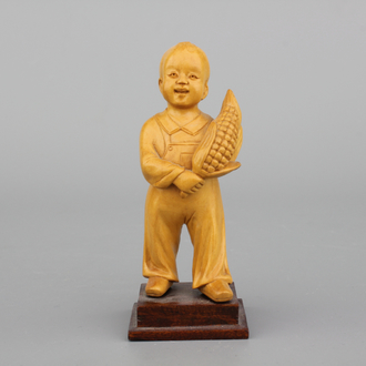 A Chinese carved wood figure of a boy with corn, Cultural Revolution, 20th C.