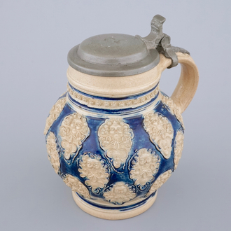 A globular Westerwald stoneware jug with applied masks, 17th C.