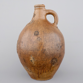 A tall Raeren saltglaze stoneware "Bartmann" or "Beardman" jug, early 17th C.