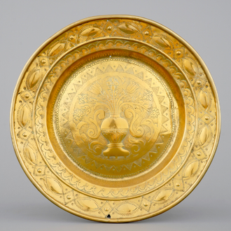 A large brass alms dish with stylised flower vase, Mechelen, 17th C.