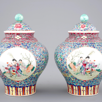 A pair of Chinese porcelain famille rose jars and covers, 20th C.