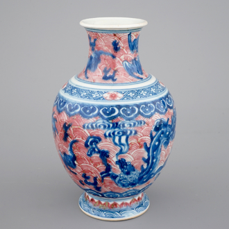 Un vase en porcelaine de Chine aux dragons en bleu et rouge, 19ème