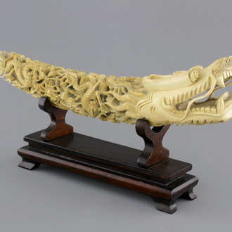 A Chinese ivory carving of a dragon on wooden stand, early 20th C.