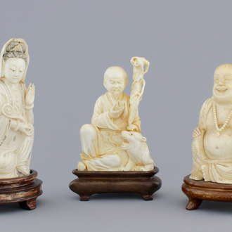 Three Chinese carved ivory figures on wooden stands, ca. 1900