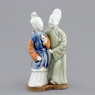 A Chinese celadon and blue-white biscuit group of a couple, Qianlong, 18th C.