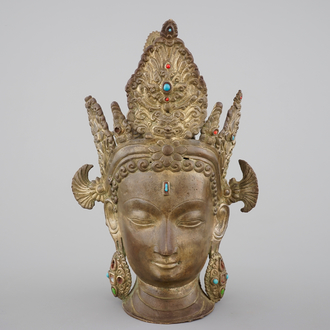 A tall gilt bronze head of a Boddhisatva with semi-precious stones, Tibet, 17/18th C.