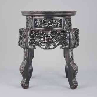 An elaborately carved Chinese hardwood vase stand with dreamstone insert, 19th C.