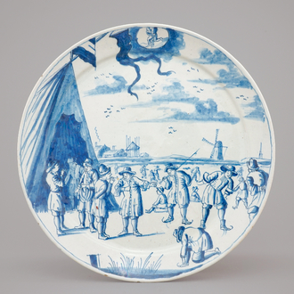 A Dutch Delft blue and white plate with skaters from the 'Zodiac' month series, early 18th C.