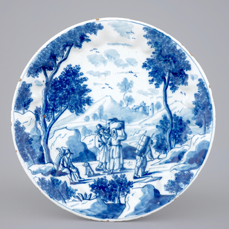 A fine Dutch Delft blue and white fluted plate with travellers in a landscape, 18th C.