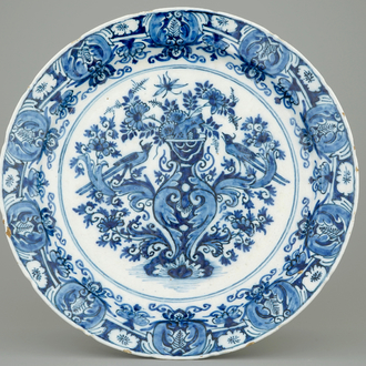 A Ducht Delft blue and white dish with birds around a vase, 18th C.