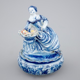 A polychrome Dutch Delft butter tub with a seated lady, 18th C.