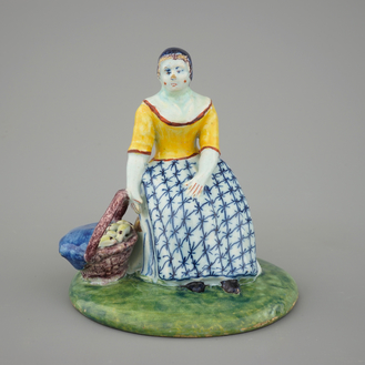 A polychrome Dutch Delft figure of a lady selling fish, 18th C.