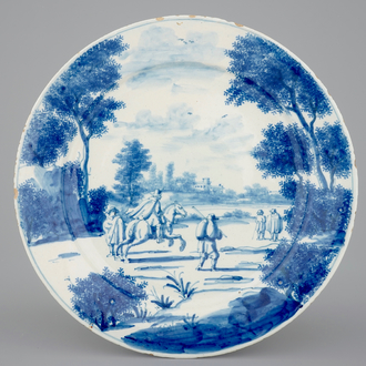 Une assiette raffinée en Delft bleu et blanc d'un paysage animé de personnages, 18e