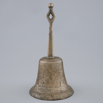A tall bronze table bell with stylised handle, 16/17th C.