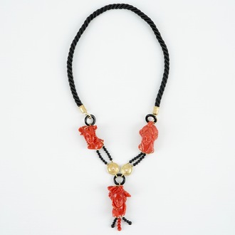 A necklace with three carved coral figures, Italy, 20th C.