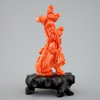 A Chinese carved red coral figure of Shou Lao on a wooden stand, 19/20th C.