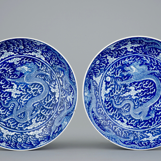 Une paire de plats aux dragons en porcelaine de Chine bleu et blanc, marque et période de Kangxi
