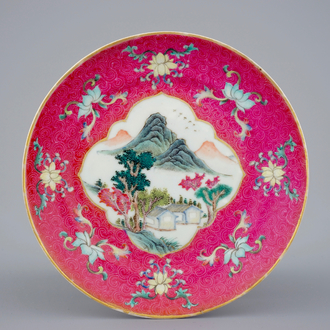 Une assiette en porcelaine de Chine à décor d'un paysage sur fond rouge rubis, 19/20ème