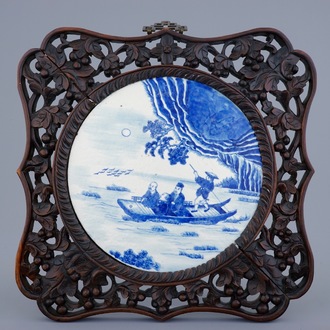 Une plaque en porcelaine de Chine bleu et blanc en cadre sculpté, 19ème