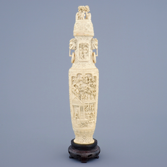 A Chinese carved ivory vase and cover on a wooden base, early 20th C.
