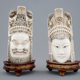 A pair of Chinese carved ivory faces on wooden stands, 19th C.