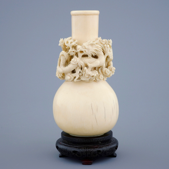 Un vase aux dragons en ivoire sculpté sur socle en bois, début du 20ème