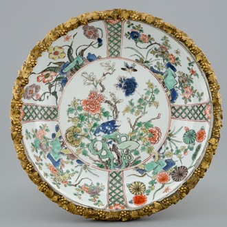 A Chinese famille verte plate with a gilt bronze mount, Kangxi