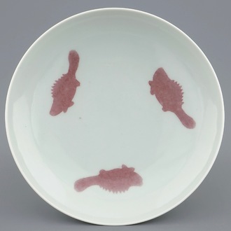 Une assiette en porcelaine de Chine à décor en rouge de cuivre de trois poissons, marque de Yongzheng, 19/20ème
