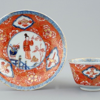 Une tasse et soucoupe en porcelaine de Chine famille bleu et blanc sur fond corail, Kangxi