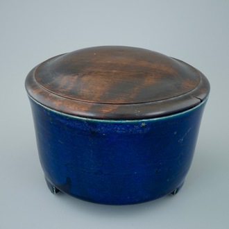 A Chinese monochrome blue cylincrical tripod incense burner with wood lid, 19th C.