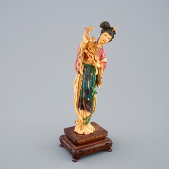 Een polychrome Chinese ivoren figuur van Guanyin op houten sokkel, 19e eeuw