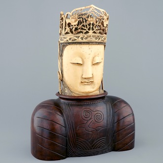 Une tête de Bouddha en ivoire sculpté sur socle en bois, Chine, 19ème