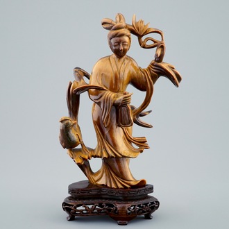 Une figure de Guanyin en pierre oeil de tigre sculptée sur socle en bois, 19/20ème