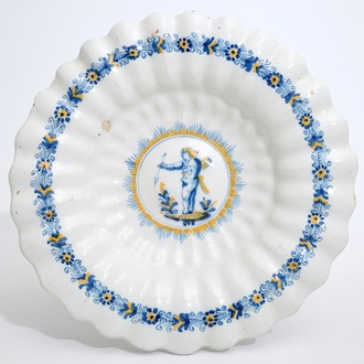 Un plat polylobé en faïence de Delft à décor d'un putto en bleu et jaune, Haarlem, 17ème