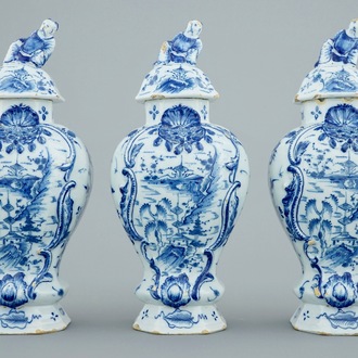 A Dutch Delft blue and white three-piece garniture with chinoiserie landscapes, 18th C.