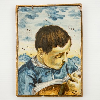 A small Italian Castelli plaque with a reading boy, 17/18th C.