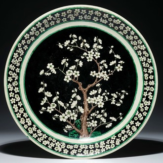 A Chinese famille noire on biscuit prunus tree charger, Kangxi