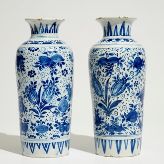 A pair of Dutch Delft blue and white cylindrical vases with tulips and flower scrolls, 17/18th C.