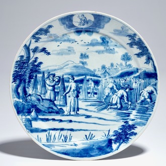 A Dutch Delft blue and white plate with peasants from the 'Zodiac' series, early 18th C.