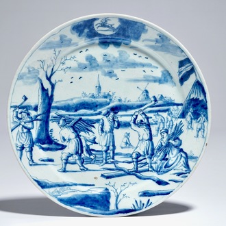 A Dutch Delft blue and white plate with lumberjacks from the 'Zodiac' series, early 18th C.
