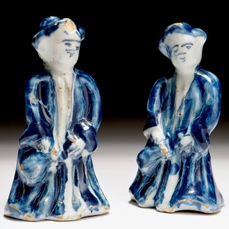 A pair of Dutch Delft blue and white miniatures of men with a jug, 18th C.