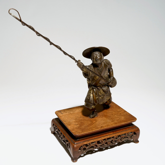 A Japanese bronze model of a fisherman on wooden base, Meiji, signed