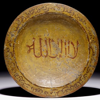 Un plat islamique en pierre sculptée à décor petit feu de calligraphie et un cadre magique sur le dos, 16/17ème