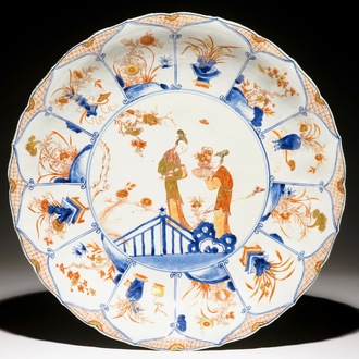 Un grand plat en porcelaine de Chine de style Imari à décor de femmes dans un jardin, Kangxi/Yongzheng