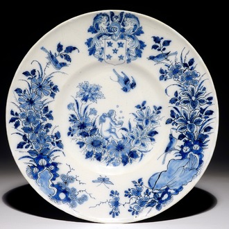 A Dutch Delft blue and white armorial plate with a putto, 17th C.