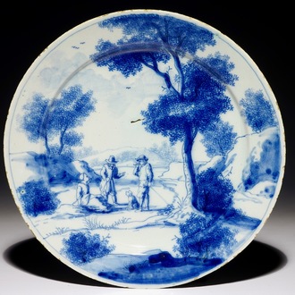 A fine Dutch Delft blue and white plate with two men and a lady below a tree, early 18th C.