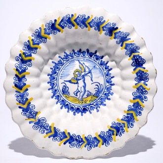 Un plat polylobé en faïence de Delft à décor d'un putto en bleu et jaune, Haarlem, 17ème