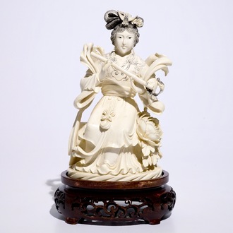 A Chinese ivory figure of a lady playing a flute on wooden base, early 20th C.